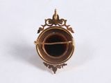 a small gold object with a black substance in it