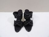a pair of black sandals with a knot on the toe