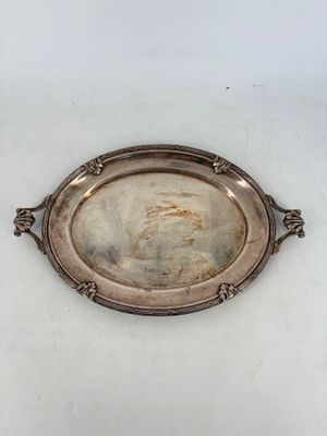 une assiette ancienne en argent sur laquelle est représentée une femme