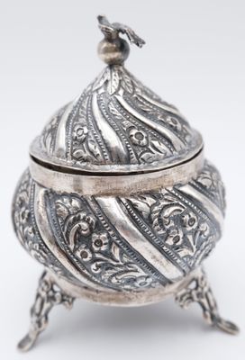 an ornate silver box with a bird on top of it