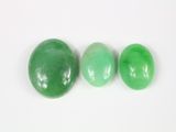 trois pierres de jade vert sur un fond blanc