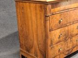 a wooden chest of drawers with a glass door on top