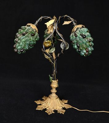 une lampe en verre vert avec un pied doré orné de feuilles