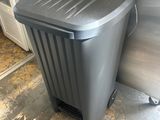 a grey trash can sitting on the floor next to a door