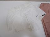 a pair of white shorts and a pair of pink pants on a table
