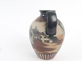 a small vase with a handle on it on a white surface