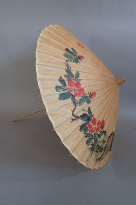a white umbrella with flowers on it on a gray surface