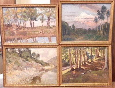 three framed paintings of a river and trees on display in a room