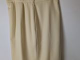 a beige skirt hanging on a hanger against a white wall