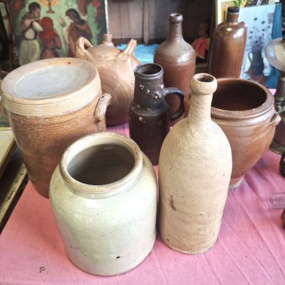 de nombreux vases posés sur une table recouverte d'une nappe rose