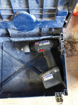 une perceuse dans une boîte à outils contenant un marteau