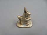 a small statue of a cat sitting on top of a table