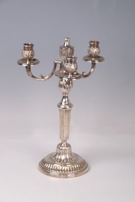 a silver candelab with three candles on it
