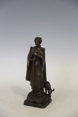 statue représentant un homme avec un chien et un chat, posée sur un socle blanc