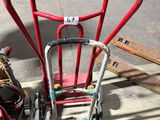 un diable rouge posé à côté d'un tas de tuyaux