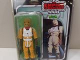 la figurine se trouve dans un emballage en plastique, posée sur une table blanche