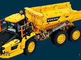 a yellow toy truck that is sitting on a blue background