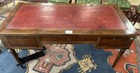 BUREAU plat en acajou gainé de cuir rouge à décor à la roule…