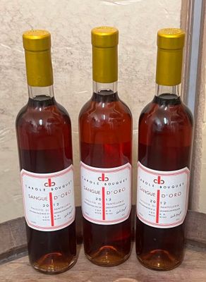 trois bouteilles de vin posées sur un tonneau en bois