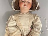 a doll that is sitting on the floor with a hat on
