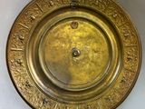 a gold plate with writing on it sitting on a table