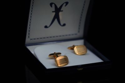 a box with two cufflinks in it and a ring in it