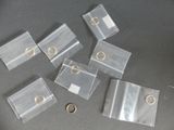 plusieurs morceaux de plastique transparent avec des anneaux dorés posés sur une table