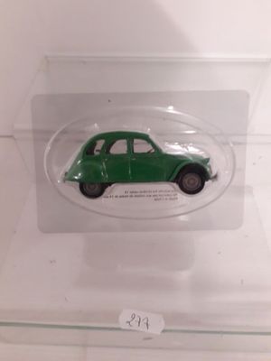 a small green car in a clear display case