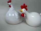 two white ceramic roosters standing next to each other