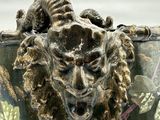 a close up of a vase with a lion head on it