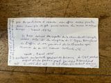 une feuille de papier sur laquelle il y a des mots, posée sur une table en bois