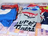 de nombreux t-shirts étalés sur une table dans une pièce