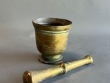 a small mortar and a wooden pestor on a table