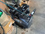 two air compressors sitting on a cart in a garage