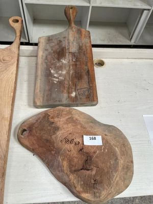several wooden cutting boards on a table with a price tag on them