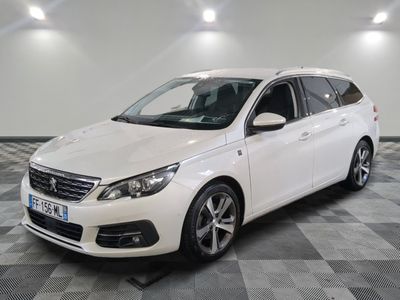 la voiture blanche est garée sur un sol en damier dans le garage