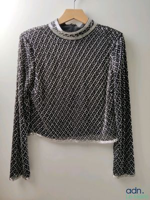 a black and white sweater hanging on a wall next to a hanger
