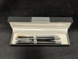 a black and gold pen in a silver case