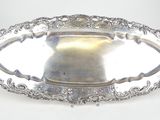 une assiette ancienne en argent, ornée d'un motif décoratif sur le bord