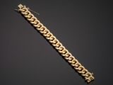a gold chain bracelet with a clasp on a black background