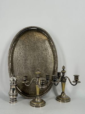 un plateau en argent avec trois bougies et un miroir