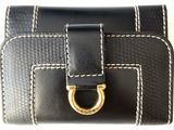 black and white leather wallet with a gold ring on top of it