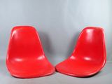 une paire de chaises rouges posées sur un sol gris