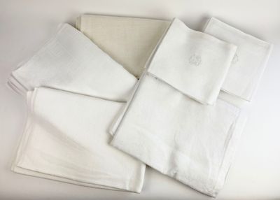 four white napkins are stacked on top of each other on a table