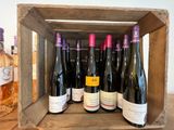 six bouteilles de vin dans une caisse en bois posée sur une table