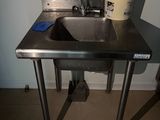 a stainless steel sink in a small room with a window