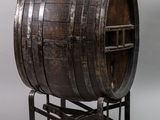 an old wooden barrel sitting on top of a metal stand