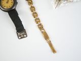 a gold watch and a black watch on a white table