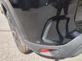 a black car with a red tail light on the side of it