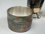 a silver cup sitting next to a silver cup on a table